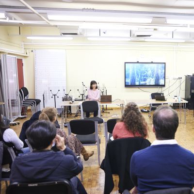 A room full of doctoral students and staff during a research presentation